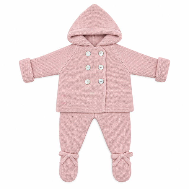 Vista frontal completa del conjunto de punto para bebé de 1 a 6 meses en color rosa maquillaje, formado por chaqueta con capucha integrada, doble botonadura delantera de nácar y polaina con pies decorados con lazos, elaborado en España.