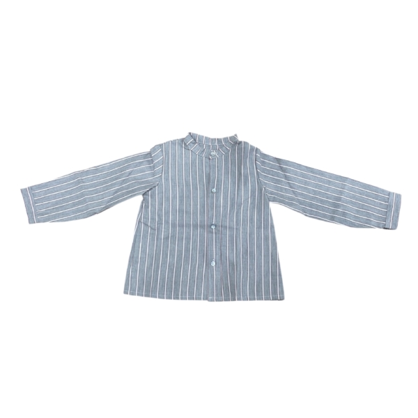 La Camisa Mao Fernando de niño es una prenda clásica con un aire moderno, ideal para cualquier ocasión especial o para looks elegantes del día a día. Forma parte de la colección Fernando, en la que también encontrarás la camisita de bebé a juego, pensada para coordinar a hermanos con un estilo cuidado y atemporal. Confeccionada en 100% algodón, esta camisa es ligera, transpirable y cómoda, perfecta para acompañar a los más pequeños durante todo el día. Su diseño en tono azul con finas rayas verticales blancas estiliza la silueta y aporta frescura, mientras que el cuello mao fruncido añade un detalle distintivo y sofisticado. Incluye manga larga recta y cierre frontal con botones, lo que facilita su uso y asegura un acabado clásico. Gracias a su confección con materiales naturales, se adapta perfectamente a la piel infantil y resulta fácil de combinar con pantalones de pana, vaqueros o bermudas. La Camisa Mao Fernando está diseñada y confeccionada en España, lo que garantiza la calidad de los materiales y el valor de la moda infantil nacional. Disponible en tallas de 3 a 6 años, es una prenda imprescindible para crear conjuntos elegantes y coordinados, especialmente en combinación con la versión para bebé de la misma colección. Características principales: Material: 100% algodón. Origen: hecho en España. Color azul con rayas verticales blancas. Cuello mao fruncido. Manga larga con corte recto. Cierre frontal con botones. Tallas disponibles: de 3 a 6 años.