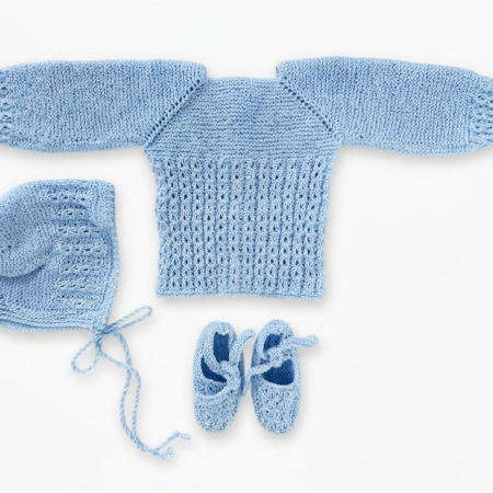 Conjunto de primera puesta para recién nacido hecho a mano en punto perlé azul clarito, compuesto por jersey calado, capota y patucos de algodón.