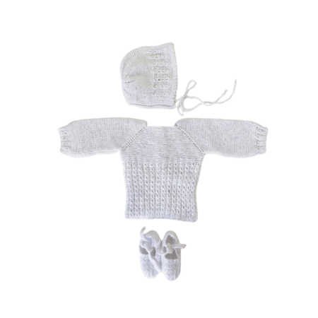 Conjunto de primera puesta para recién nacido hecho a mano en punto perlé blanco, compuesto por jersey calado, capota y patucos de algodón.