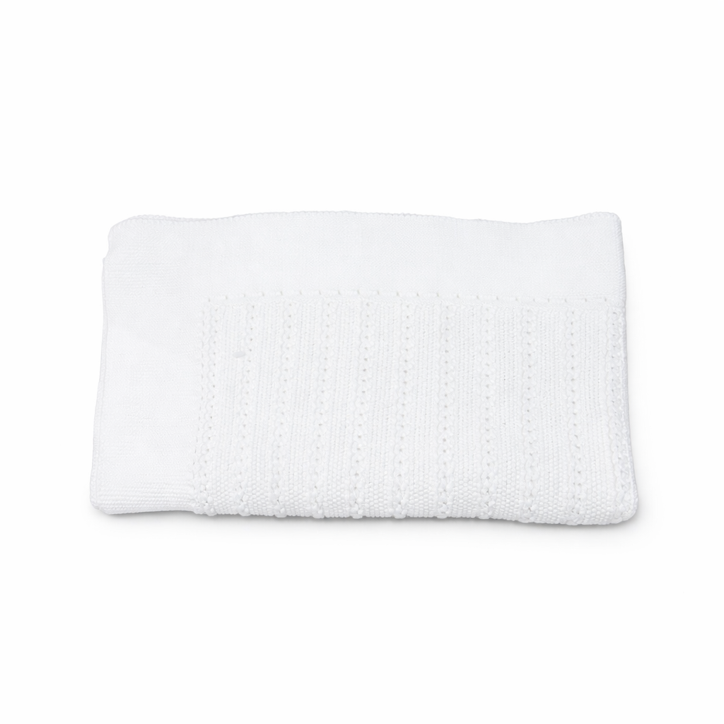 Manta de punto para bebé en color blanco con diseño de ochos, marca Machú, hecha a mano en España con 100% algodón premium