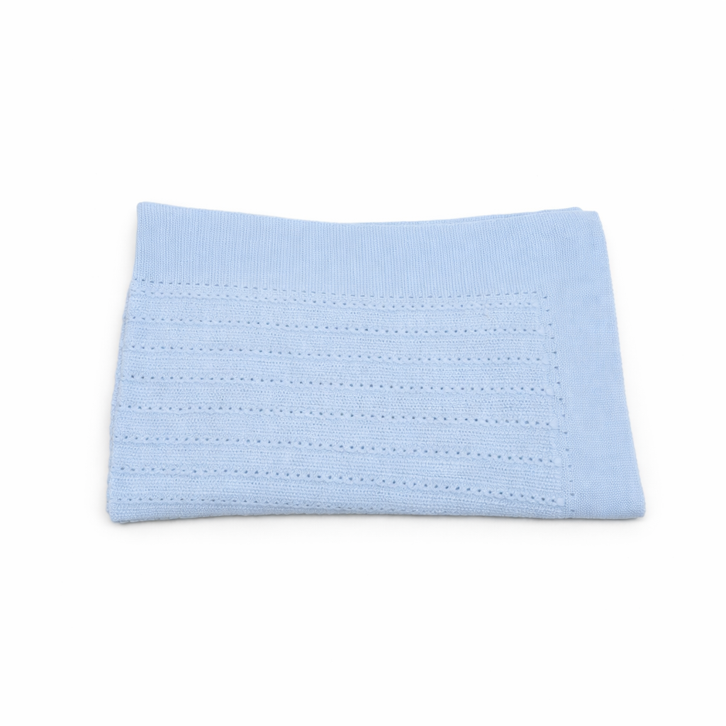 Manta de punto para bebé en color azul celeste con diseño de ochos, marca Machú, hecha a mano en España con 100% algodón premium