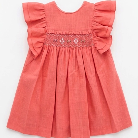 Vestido coral para niña de la marca Machu, hecho a mano en España, con panel central de nido de abeja bordado a mano, mangas de volante y confeccionado en 100% algodón.