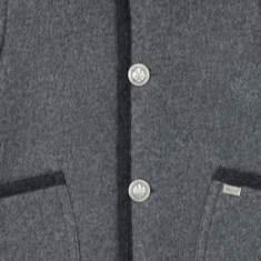 Detalle en primer plano de los botones grabados de estilo tradicional y el ribeteado lateral de la chaqueta austriaca.