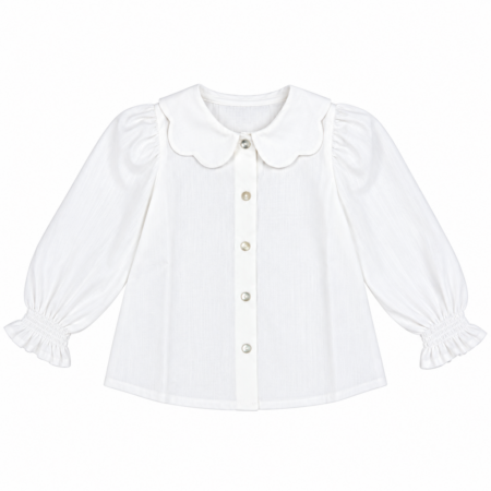Vista frontal de la blusa infantil blanca de 100% algodón con cuello de ondas, abotonadura delantera y manga larga fruncida para niñas de 4 a 10 años, producto elaborado en España.