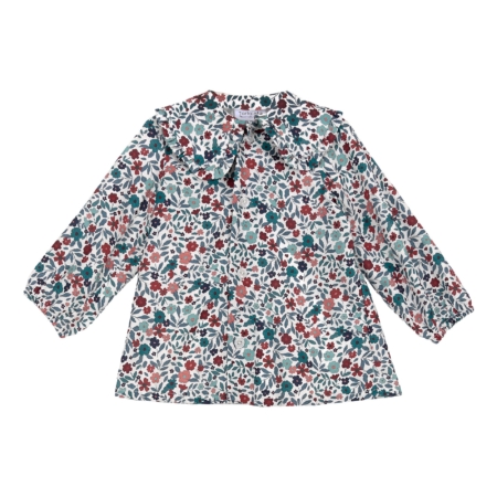 Vista frontal de la blusa infantil con estampado floral multicolor, manga larga con puños fruncidos y cuello amplio con volantes para niñas de 2 a 8 años, producto elaborado en España.