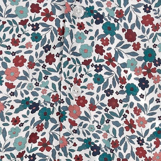 Detalle cercano del tejido 100% algodón del vestido Nueva York, mostrando el estampado de flores y hojas en tonos rojos, azules y verdes.