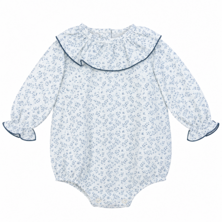 Vista frontal de la rana para bebé con con estampado floral en tonos grises y azulados, manga larga con puños fruncidos y gran gran redondo cinta castillo, elaborado producto en España.
